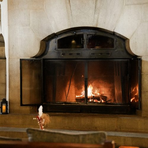Cheminée monumentale en pierre avec feu allumé dans le salon du Fairmont Montebello au Québec