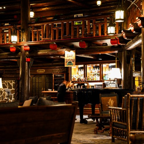 Bar du Fairmont Montebello avec structure en bois, piano et ambiance chaleureuse du lodge