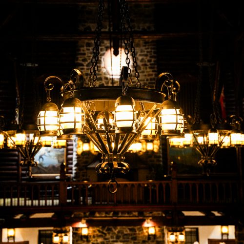 Lustres suspendus éclairant la grande salle en bois et pierre du Fairmont Montebello