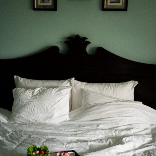 Petit-déjeuner servi en chambre sur un lit d’hôtel à Hoi An, photographié par Chloé et Aurore.