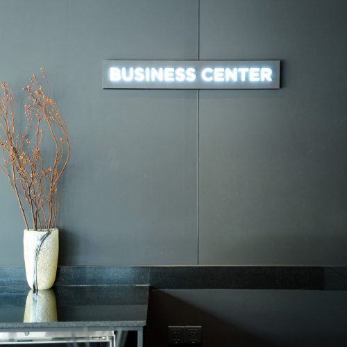 Business Center du Maison Hotel Bangkok avec signalétique lumineuse et espace de travail moderne.