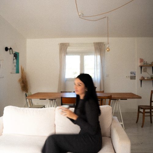 Personne assise sur un canapé dans le salon d’un gîte du Mas Cantegril, intérieur lumineux et chaleureux.