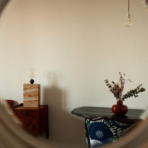 Détails de décoration à l’intérieur d’un gîte du Mas Cantegril, avec table, lampe et vase dans une ambiance douce.