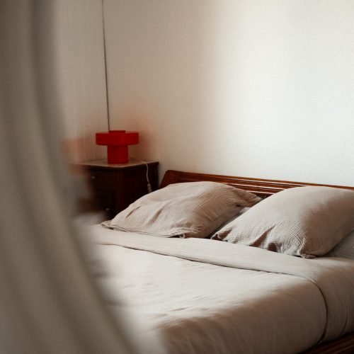 Lit double dans une chambre d’un gîte du Mas Cantegril, avec linge clair et éclairage doux.