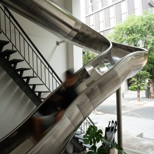 Toboggan métallique installé dans les espaces communs de l’hôtel Meander Saigon.