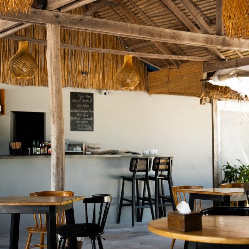 Intérieur du restaurant du The Secret Garden Koh Rong avec mobilier en bois et fibres naturelles, photo par chloeandaurore