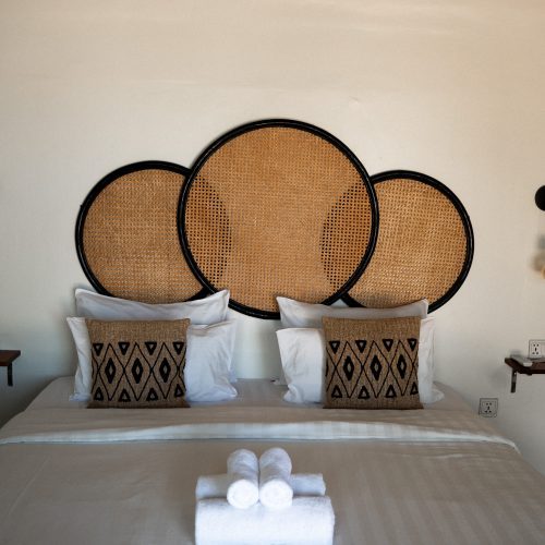 Lit king-size avec tête de lit en rotin dans une chambre du Secret Garden Koh Rong.