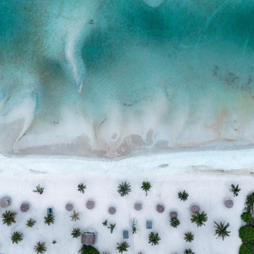 Vue aérienne de la plage et du resort The Secret Garden Koh Rong avec palmiers et eau turquoise.