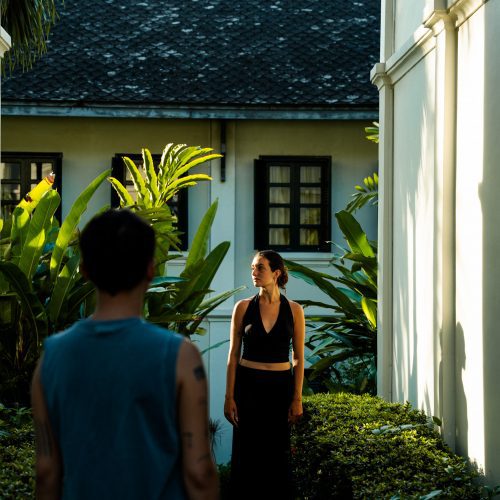 Deux personnes se faisant face dans une allée du jardin tropical du Villa Maly à Luang Prabang.